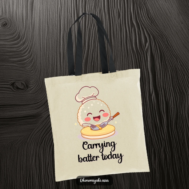 Funny tote bag showcasing a grinning rice ball chef flipping a pancake, ideal for stylish and humorous shopping.